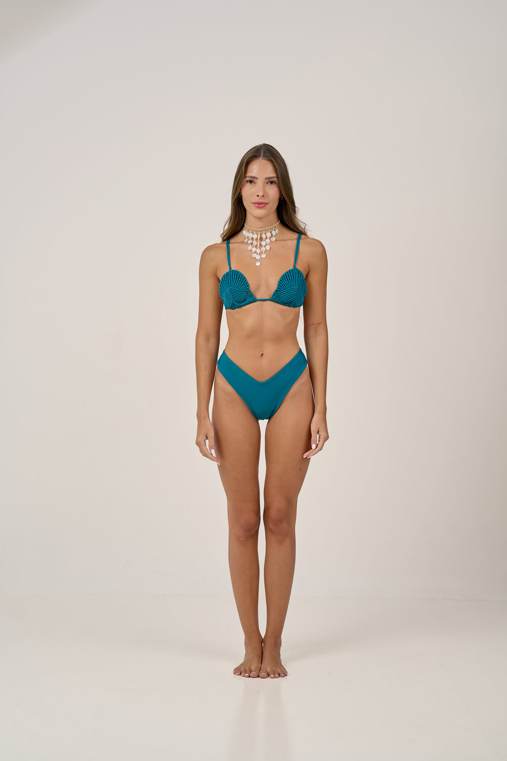 Inspired by Brazil’s vibrant beaches, the Rio bikini features hand-woven shell-shaped cups and a high-cut bottom that flatters every curve. In a deep ocean teal, it’s made for making waves in style.