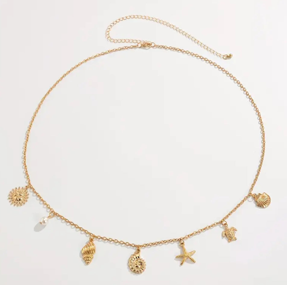 A delicate golden waist chain adorned with seashells, a starfish, and ocean-inspired charms. Designed to capture the essence of summer, it adds a playful yet elegant touch to your swimwear or beachside outfits.
